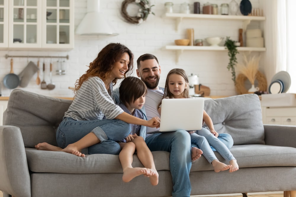 stock-photo-happy-young-family-with-little-kids-sit-on-sofa-in-kitchen-have-fun-using-modern-laptop-together-1660546246