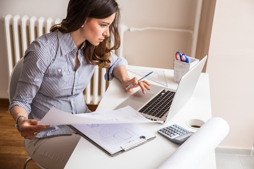 Attractive Young Woman Using Laptop And Working On Her Finances At Home